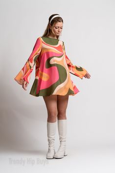 Step into the enchanting world of 70s Dress Style with our Bell Sleeve Dress, a captivating piece that encapsulates the spirit of the groovy era. This 60s 70s mini dress is a Boho Dress with a distinctive Bohemian touch, perfect for those seeking a Hippie Dress that exudes both charm and style.The Multicolor Tent Dress features a groovy pattern print inspired by the psychedelic aesthetics of the 70s, creating a visually striking and unique look. This slip-on dress is designed for ease and comfort, complemented by bell sleeves that add a touch of vintage flair. The single button enclosure behind the neckline enhances the Bohemian feel of the dress.Crafted from chiffon and fully lined material, this Groovy 70s Style Dress ensures a luxurious feel and graceful movement. The 100% polyester con Rich 60s Fashion, 70s Dinner Party Fashion, Bell Sleeve Dress 70s, 60’s Dress, 60s Fashion Hippie Woodstock, 70s Birthday Outfit, 70s Dress Style, 70’s Fashion Women, 70s Editorial Photoshoot