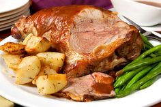 a white plate topped with meat, potatoes and green beans