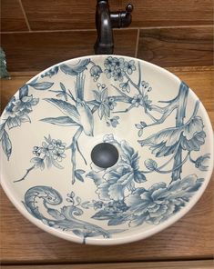 a blue and white sink sitting on top of a wooden counter