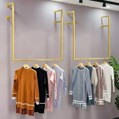 clothes are hanging on the wall in front of a mirror and coat rack with hooks