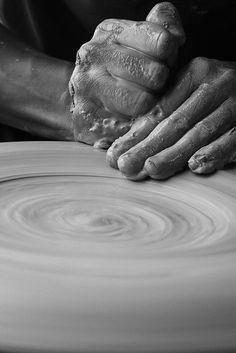 a person is making something out of clay on a potter's wheel with their hands