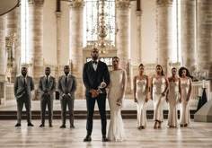 a group of men and women in formal wear standing next to each other