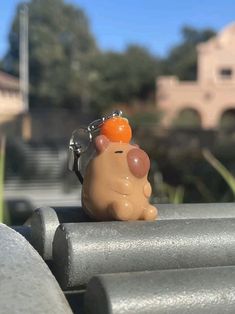 a small toy animal sitting on top of a metal rail