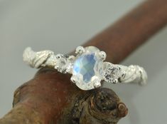 a close up of a ring on top of a wooden stick with a stone in the middle