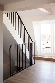 an empty room with white walls and black railing