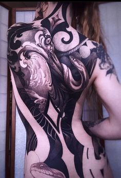 the back of a woman's body is covered in black and white art work