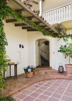 an outdoor patio with potted plants on the side and stairs leading up to it