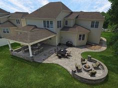 an aerial view of a house with patio and fire pit in the middle of it