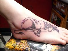 a person with a tattoo on their foot that has a tiger laying down on it