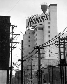 an old black and white photo of the hamm's sign in front of some power lines