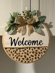 a welcome sign hanging from the side of a door with a leopard print design on it