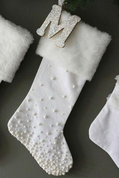 three christmas stockings with white fur, one has a monogrammed m on it