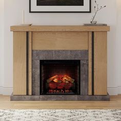 a fire place in a living room with a painting on the wall above it and a rug