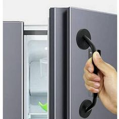 a hand is holding the door handle to an open refrigerator