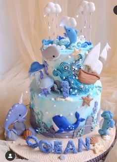 a blue and white baby shower cake with sea animals on it's top tier