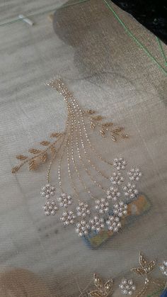 an embroidered cloth with beaded flowers and leaves on the side, sitting on a table