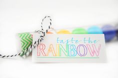 there is a tag that says taste the rainbow next to some colorful balls and twine