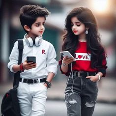 two children are walking down the street with headphones on and looking at their phones