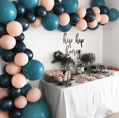 a table topped with lots of balloons and desserts