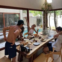 a group of people sitting around a table with food and drinks in front of them