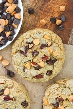 chocolate chip cookies with nuts and dried cherries next to a bowl of raisins