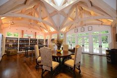 a dining room with wooden floors and vaulted ceiling