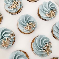 cupcakes with blue frosting and gold decorations