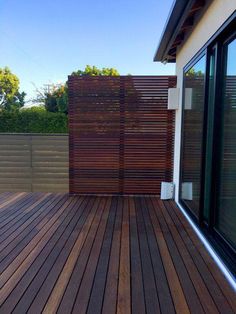 a wooden deck with sliding glass doors on it