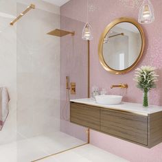 a bathroom with pink tile and gold fixtures, including a round mirror above the sink