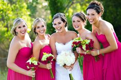 a group of women standing next to each other holding bouquets