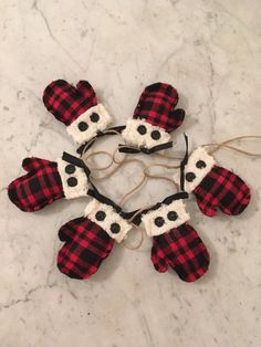 four mittens are arranged in the shape of a snowflake on a marble surface