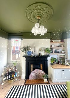 a living room filled with furniture and a fire place under a chandelier hanging from the ceiling