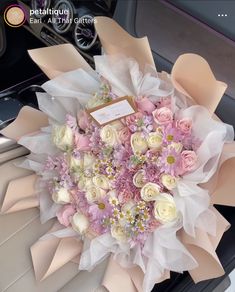 a bouquet of pink and white flowers sitting on top of a car dash board in the passenger seat