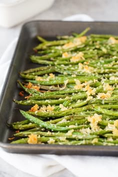 cooked asparagus with parmesan cheese on top in a baking pan, ready to be served