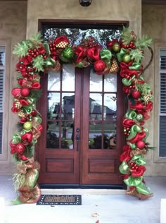 the front door is decorated with red and green decorations