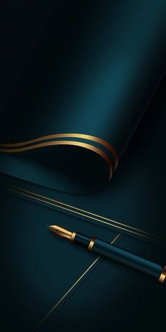 a pen sitting on top of a black table next to a blue sheet with gold trim