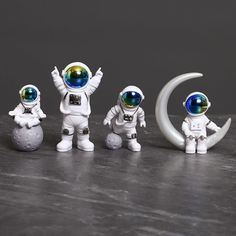 three small figurines are posed in front of the moon and two other figures