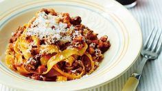 a white plate topped with pasta covered in sauce