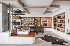 the inside of a shoe store with wooden shelves and leather handbags on shelving