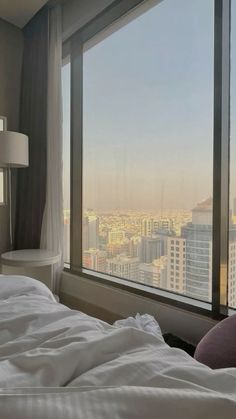 a bedroom with a large window overlooking the city