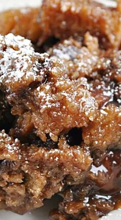 a close up of some food on a plate with powdered sugar and syrup around it