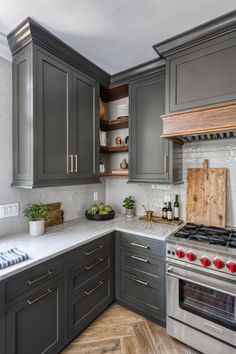 a kitchen with gray cabinets and white counter tops