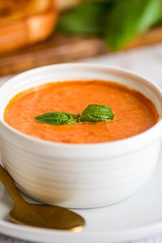 a bowl of tomato soup on a white plate