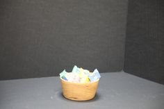 a wooden basket filled with lots of different types of tissues on top of a table