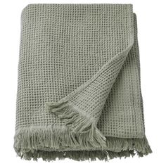 a light green blanket with fringes on it