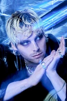 a man with blonde hair and piercings posing for a photo