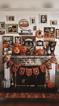 a fireplace decorated for halloween with pumpkins and pictures on the mantle, along with other decorations