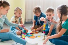 five children playing with toys on the floor