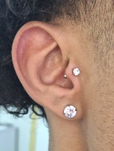 a close up of a person's ear with two small diamond studs on it