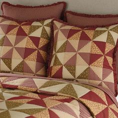 a red and tan quilted bed with pillows